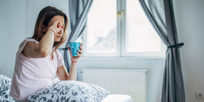 a tired woman holding a cup of tea