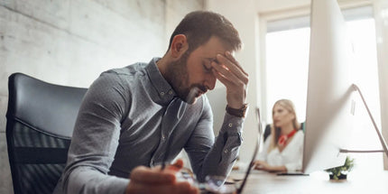 a focused individual diligently working at a desk with a computer