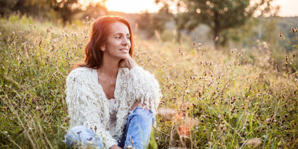 a person sitting in a field surrounded by greenery and small flowers