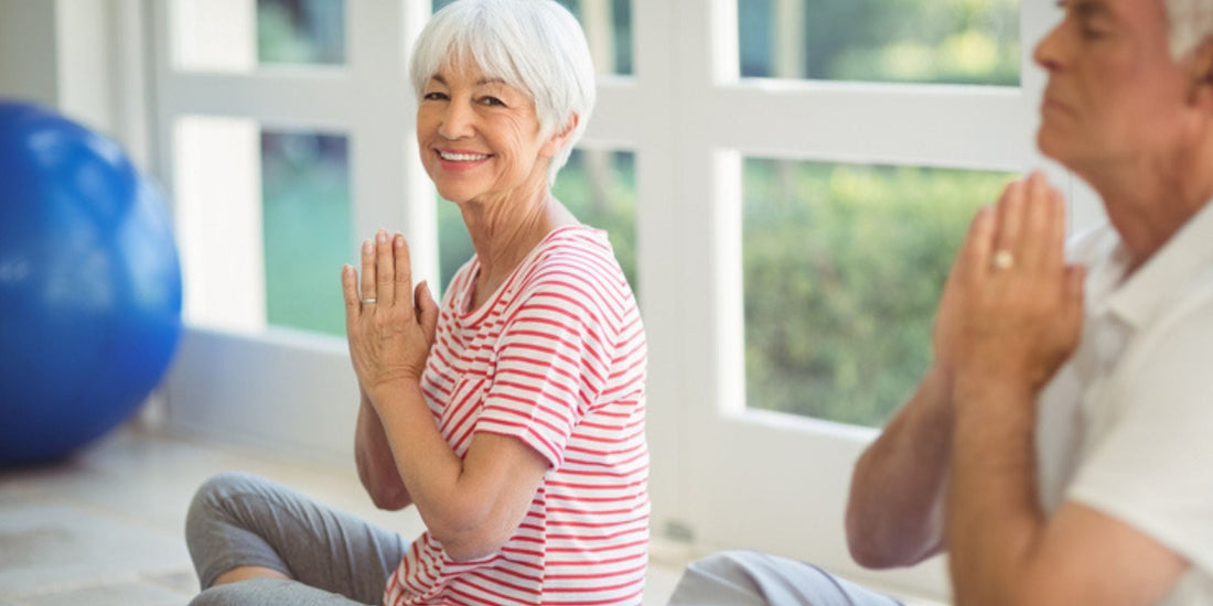 an elderly lady smiling at the camera while doing light exercise