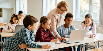 Students in a classroom with teacher assistance