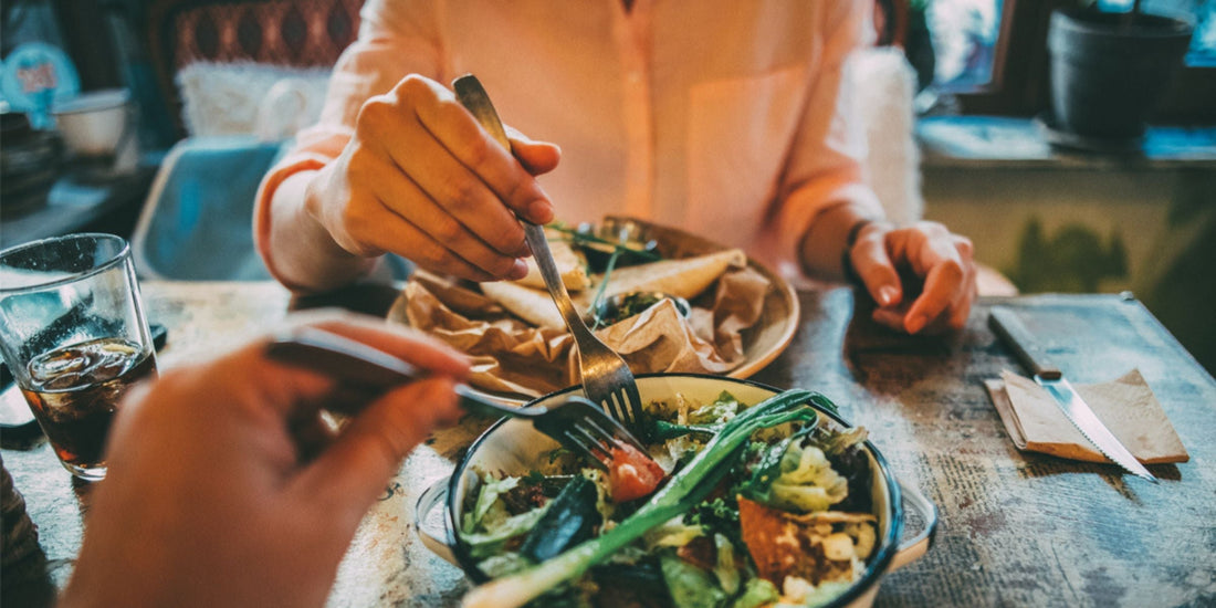 two people sitting at a table sharing a meal