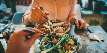 two people sitting at a table sharing a meal