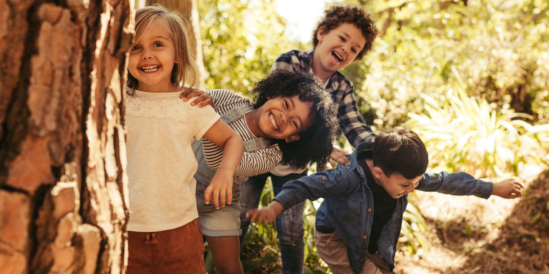 children playing near a tree in a lush green environment