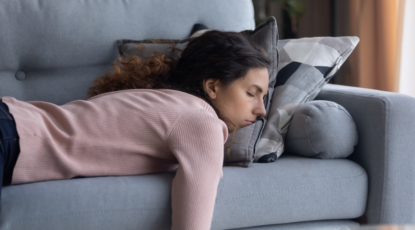 Woman Slumped in Tiredness & Exhaustion on Couch