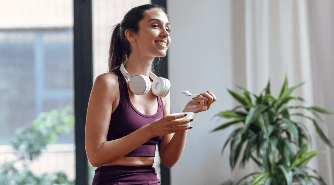 Woman in active wear enjoying a prebiotic and probiotic yoghurt