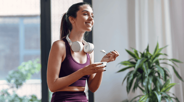 Woman in active wear enjoying a prebiotic and probiotic yoghurt