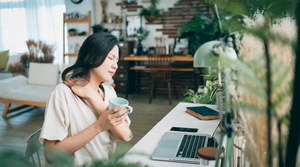 Woman in Pain at Desk with Coffee in Hand