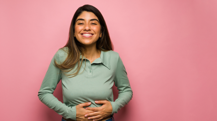 Smiling woman with her hands on her belly