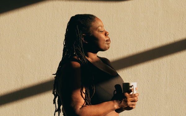 Woman standing and facing the sunlight on her body.