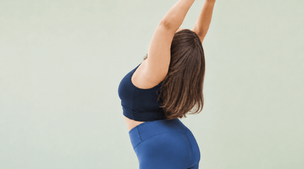 Woman in active wear stretching arms above head