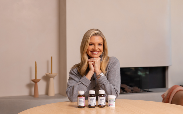 Rebecca Maddern smiling with Metagenics products in front