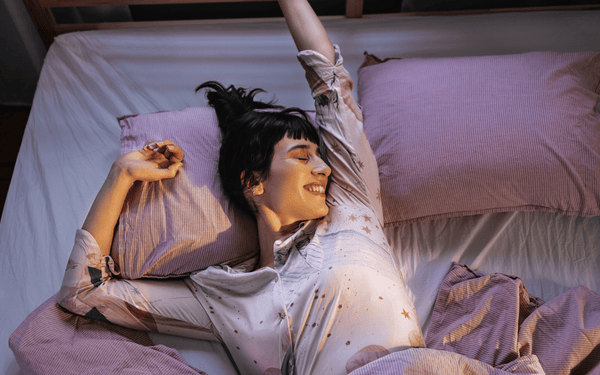 Woman waking up well rested in bed