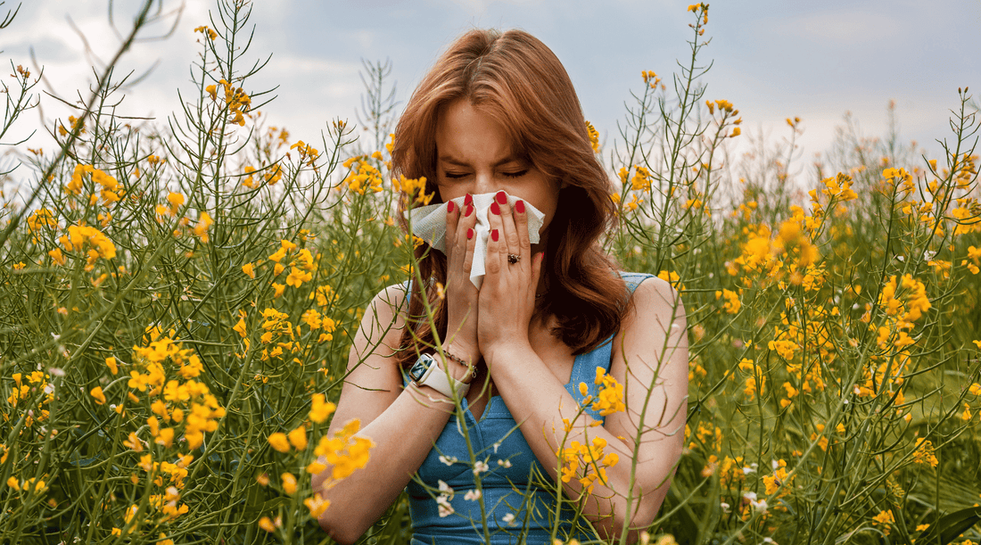 Woman is sneezing in a field of flowers