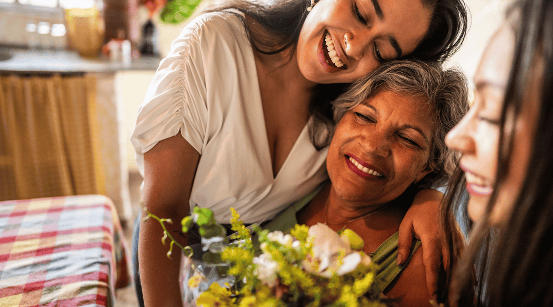 Older adult smiling gently while surrounded by supportive family.