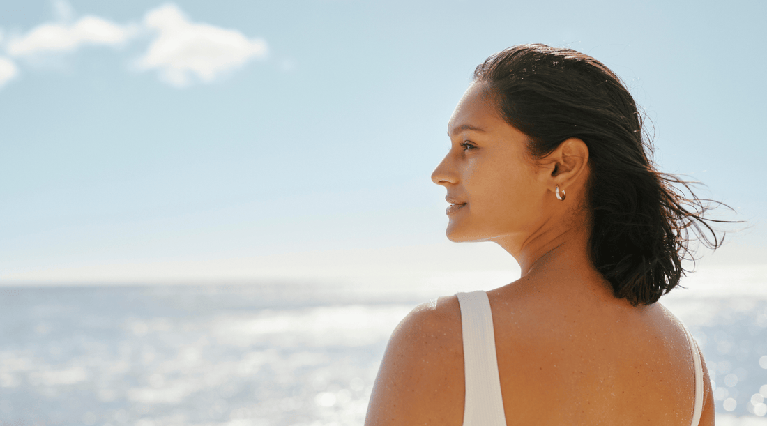 Woman looking across the ocean skyline