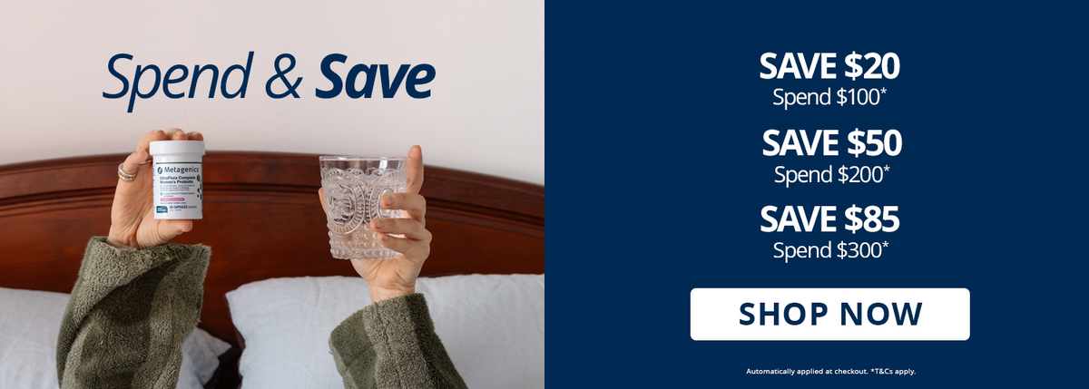 Spend & Save: save $20 when you spend $100, $50 when you spend $200, or $85 when you spend $300. Automatically applied at checkout. T&Cs apply. Person in bed holding up Metagenics UltraFlora Complete Women's Probiotic and a glass of water.