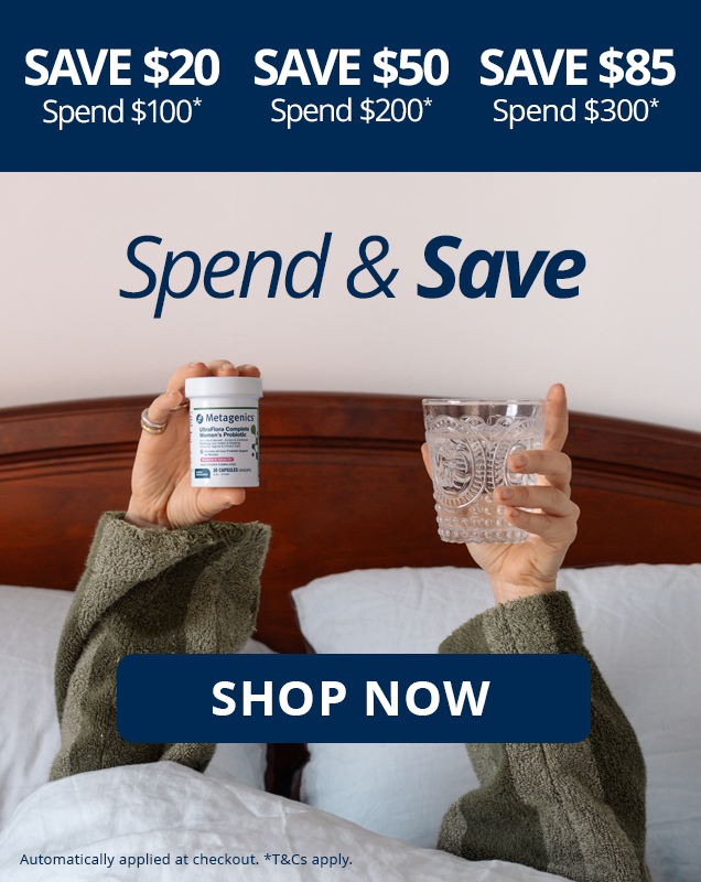 Spend & Save: save $20 when you spend $100, $50 when you spend $200, or $85 when you spend $300. Automatically applied at checkout. T&Cs apply. Person in bed holding up Metagenics UltraFlora Complete Women's Probiotic and a glass of water.