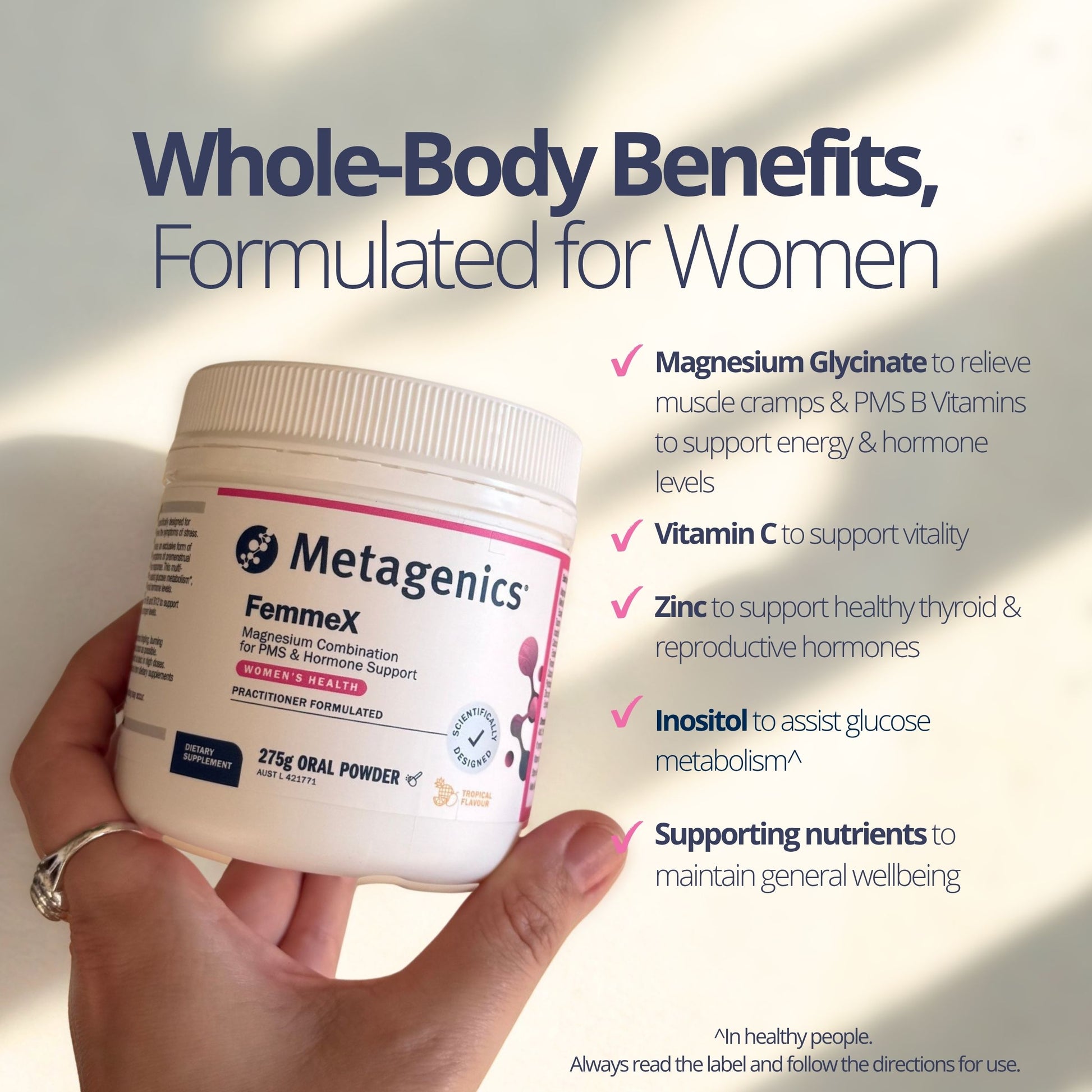 A hand holding a white jar of Metagenics FemmeX magnesium powder, with promotional text on a light beige background highlighting whole-body benefits for women.